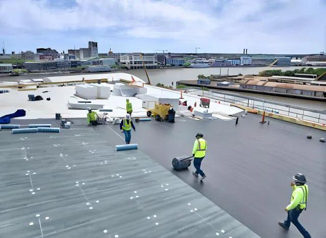 Roofing crew working on a large commercial roof near the waterfront